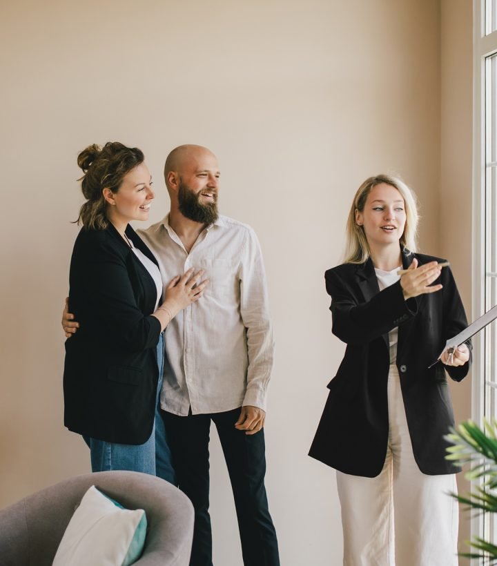 Real estate agent demonstrating a new apartment to a happy couple. Buying a property.